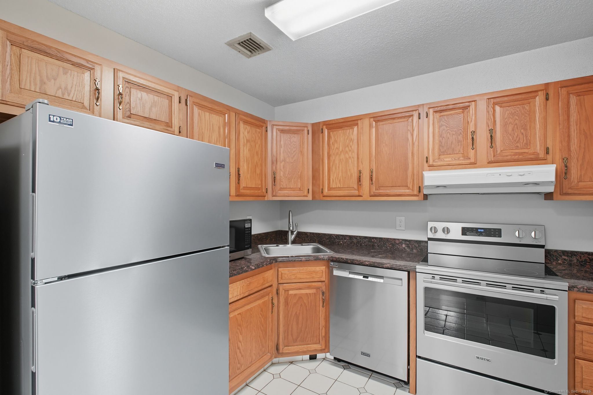 402 Twin Circle Drive, Unit 402 South Windsor, CT 06074 - Photo 7 of 18 a kitchen with stainless steel appliances a refrigerator sink and cabinets