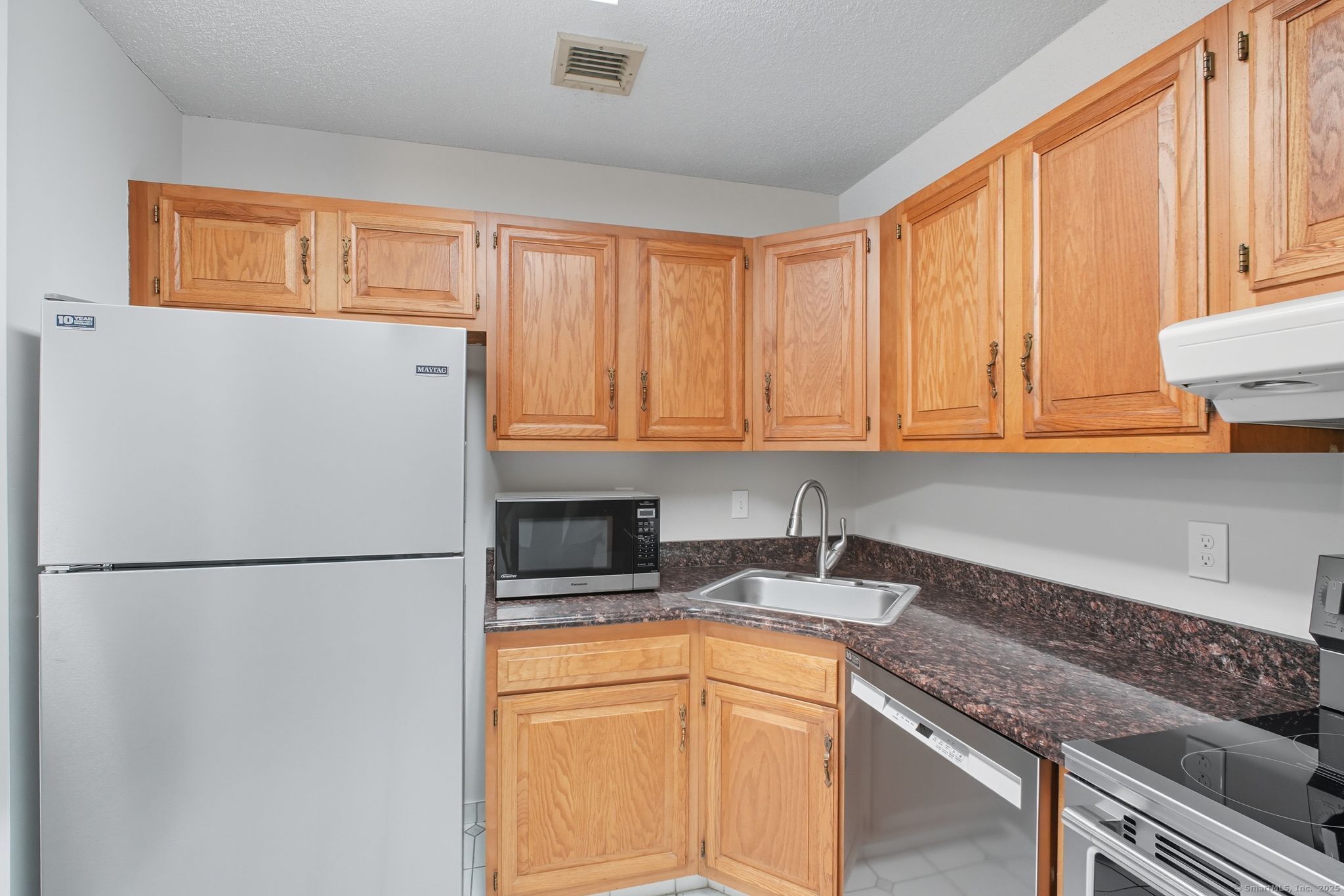 402 Twin Circle Drive, Unit 402 South Windsor, CT 06074 - Photo 8 of 18 a kitchen with stainless steel appliances granite countertop a refrigerator sink and cabinets