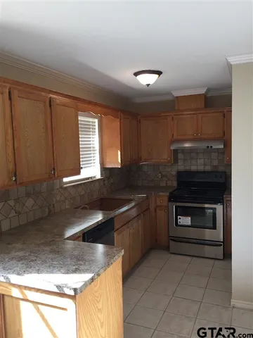 a kitchen with granite countertop a stove and a sink