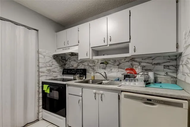 a kitchen with stainless steel appliances granite countertop a sink a stove and cabinets