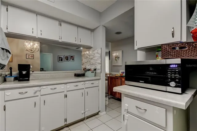 a kitchen with white cabinets and appliances