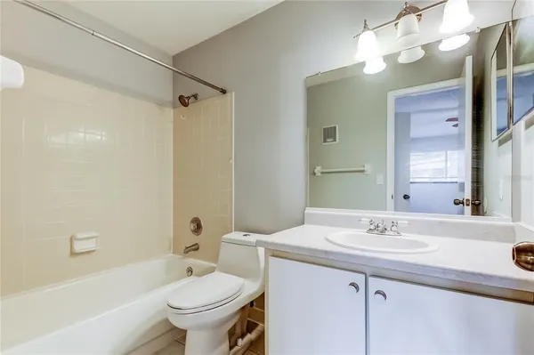 a bathroom with a sink a toilet a mirror a bathtub and shower