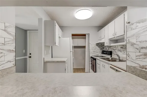 a kitchen with stainless steel appliances granite countertop a refrigerator and a stove top oven