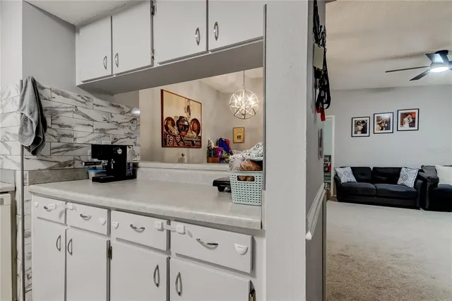 a living room with furniture and a refrigerator
