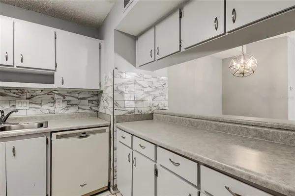 a kitchen with white cabinets and appliances