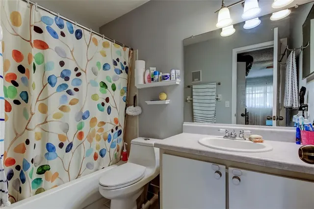 a bathroom with a sink a toilet and shower curtain