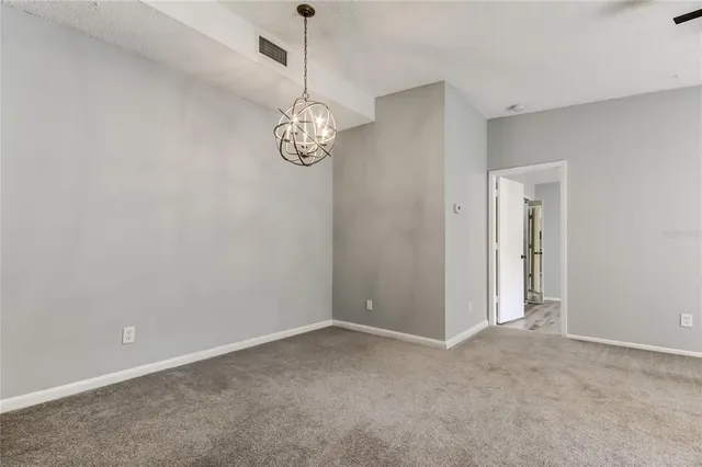 an empty room with a ceiling fan and window