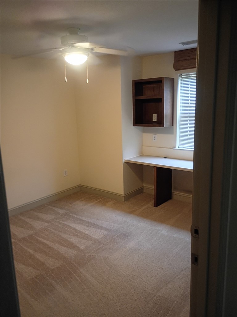 Plush carpeting and a built-in workstation create a functional and comfortable workspace.