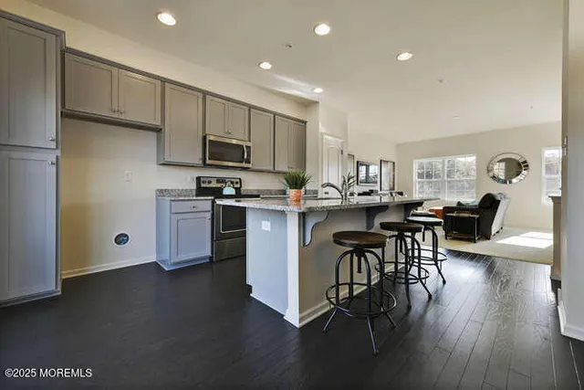 a kitchen with stainless steel appliances a table chairs refrigerator microwave and cabinets