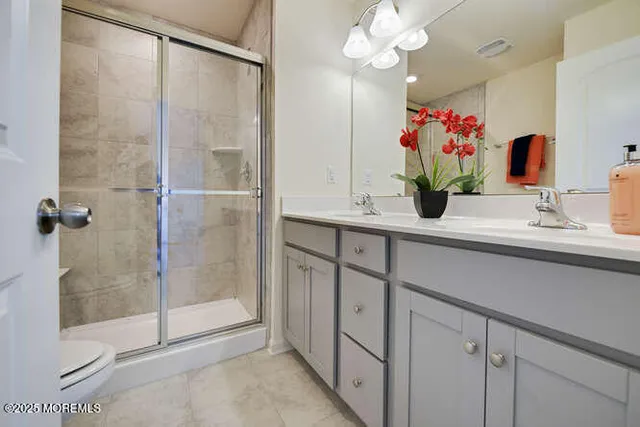 a bathroom with a granite countertop sink a mirror and a shower