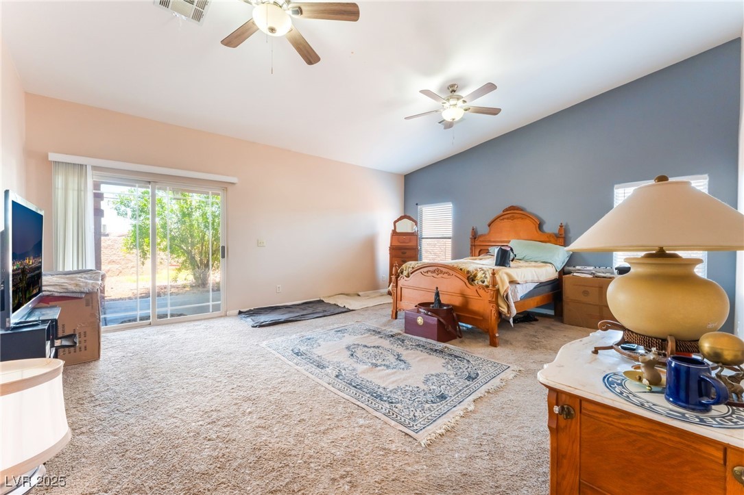 4656 East Desert Inn Road Las Vegas, NV 89121 - Photo 24 of 98 Bedroom featuring vaulted ceiling, carpet floors, access to exterior, multiple 4656 E DI windows, and ceiling fan