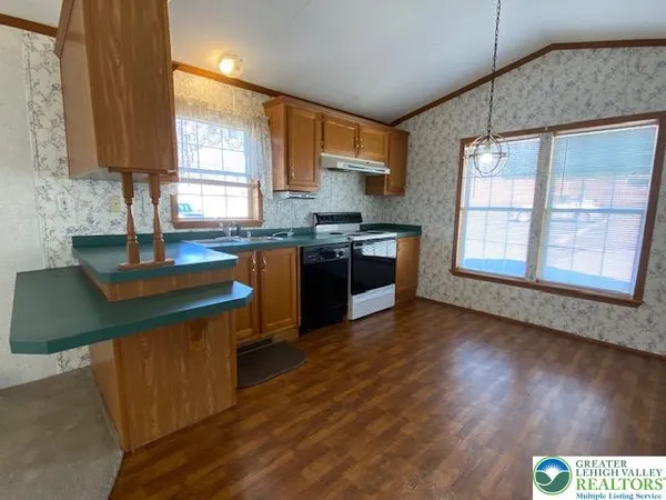 a kitchen with stainless steel appliances granite countertop wooden floors and sink