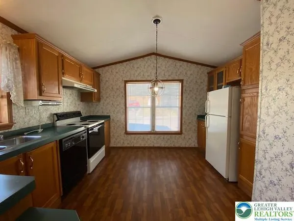 a kitchen with granite countertop a refrigerator a sink dishwasher a stove and white countertops with wooden floor