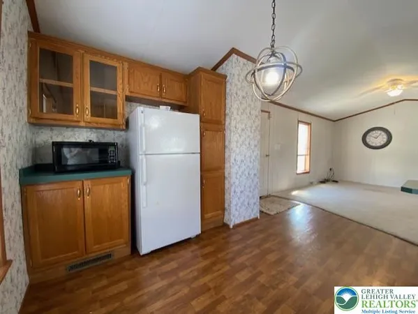 a view of a kitchen with wooden floor and cabinets