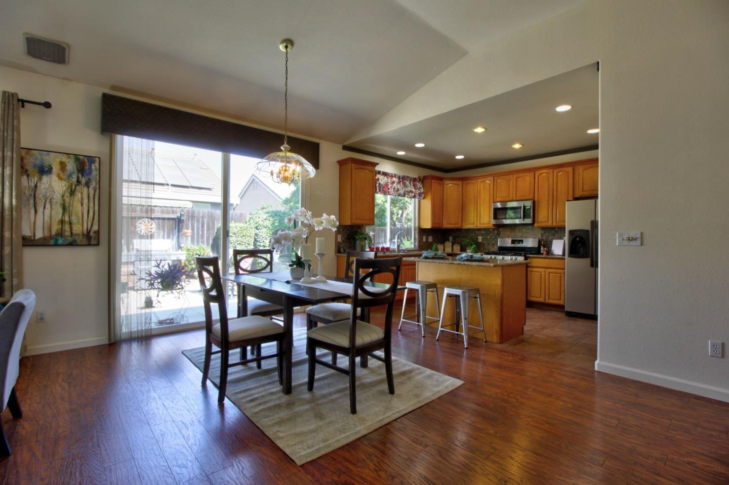 1833 Rail Street Manteca, CA 95337 - Photo 11 of 33 a kitchen with kitchen island granite countertop wooden floors and a view of living room