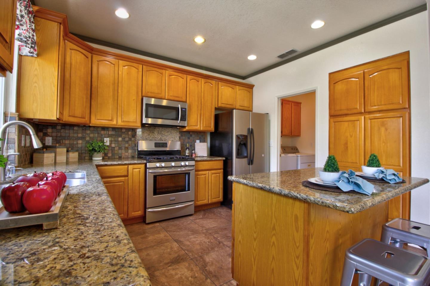1833 Rail Street Manteca, CA 95337 - Photo 16 of 33 a kitchen with stainless steel appliances granite countertop sink stove top oven and cabinets