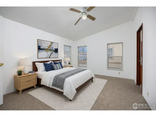 a spacious bedroom with a bed a window and a painting on the wall