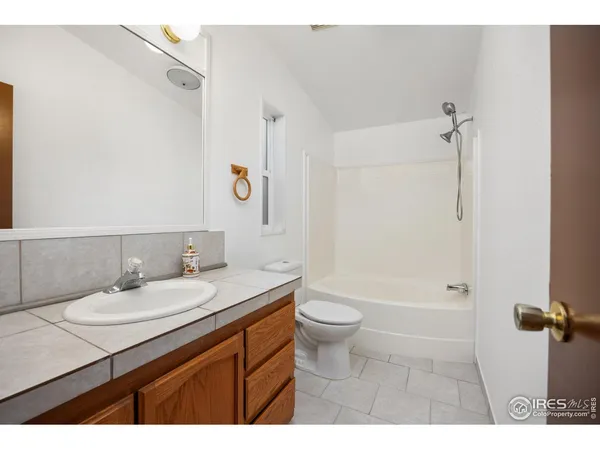 a bathroom with a sink a toilet a mirror and shower