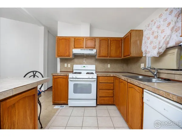 a kitchen with stainless steel appliances granite countertop a sink a stove and cabinets
