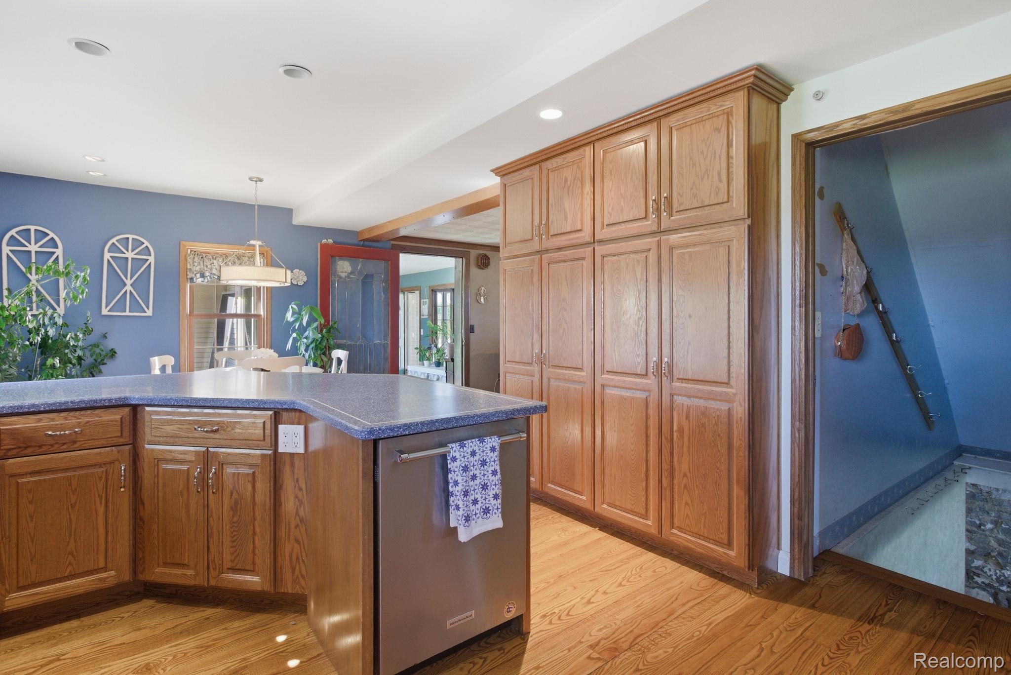 14104 Carleton West Road Carleton, MI 48117 - Photo 22 of 58 Kitchen featuring wood finish cabinets, stainless steel dishwasher, light wood finished floors, and hanging light fixtures