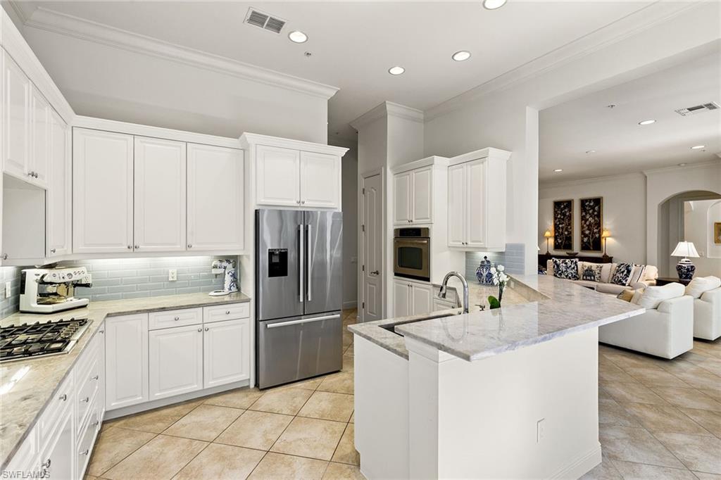 28540 Calabria Court, Unit 102 Naples, FL 34110 - Photo 17 of 32 a kitchen with stainless steel appliances granite countertop a sink refrigerator and cabinets