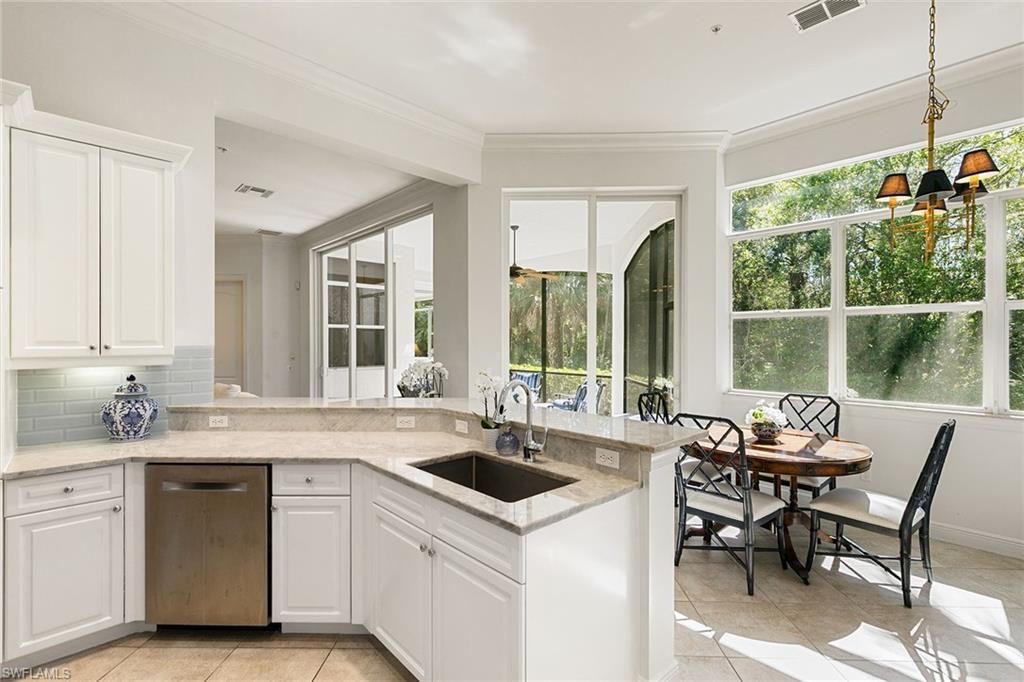 28540 Calabria Court, Unit 102 Naples, FL 34110 - Photo 18 of 32 a kitchen with sink a window and chairs
