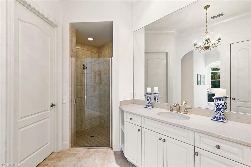 28540 Calabria Court, Unit 102 Naples, FL 34110 - Photo 25 of 32 a bathroom with a double vanity sink shower and a mirror