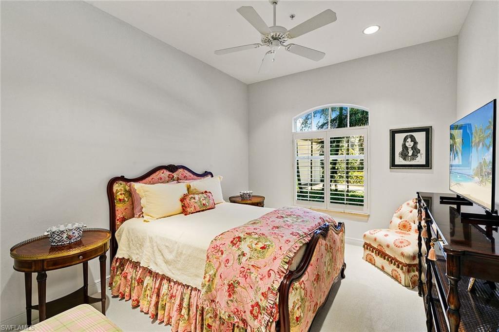 28540 Calabria Court, Unit 102 Naples, FL 34110 - Photo 26 of 32 a bedroom with a bed and wooden floor