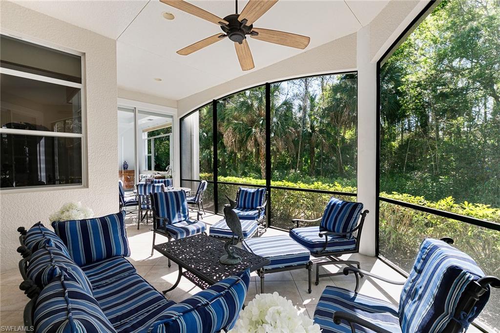 28540 Calabria Court, Unit 102 Naples, FL 34110 - Photo 31 of 32 a living room with furniture and floor to ceiling windows