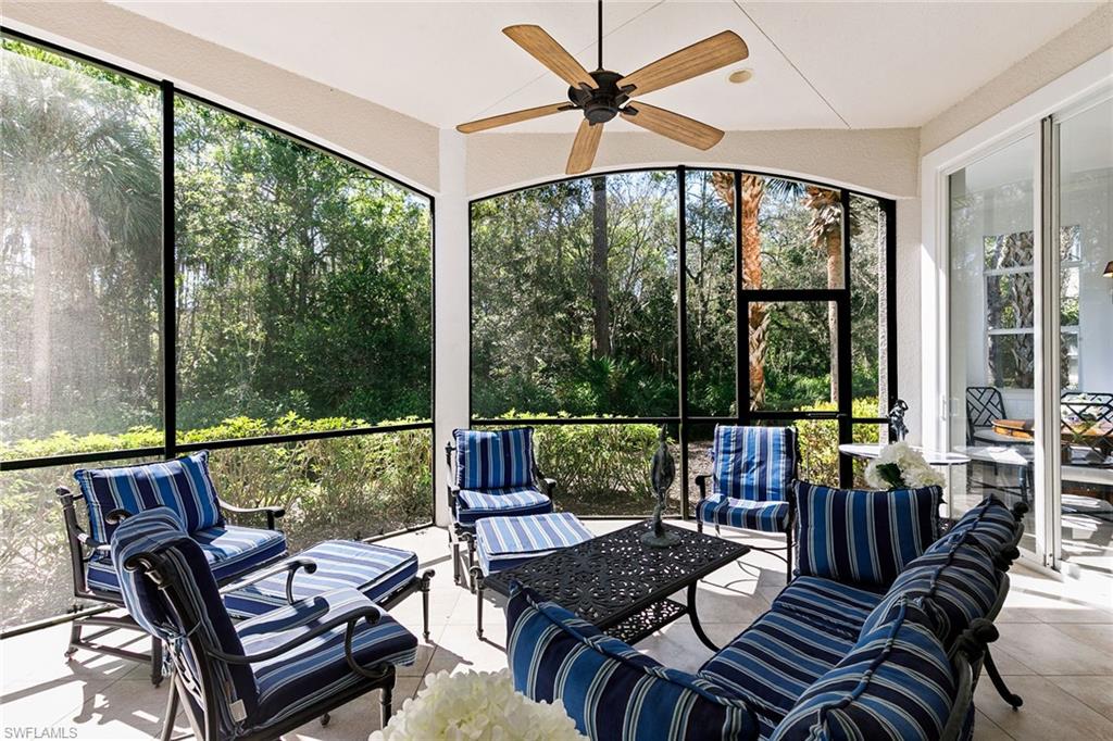 28540 Calabria Court, Unit 102 Naples, FL 34110 - Photo 5 of 32 a living room with furniture and floor to ceiling windows