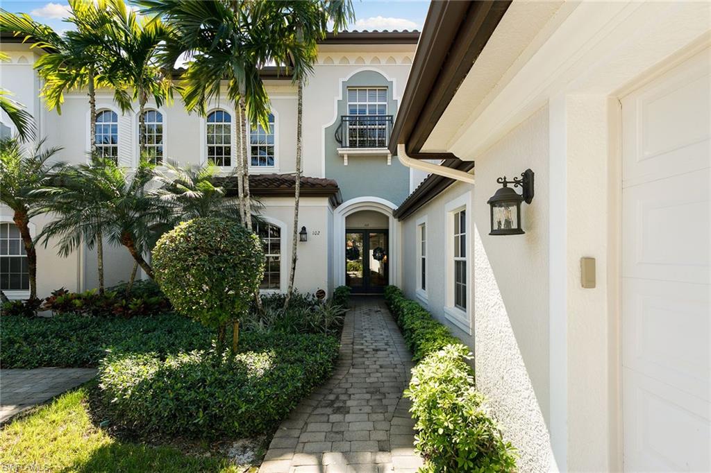 28540 Calabria Court, Unit 102 Naples, FL 34110 - Photo 7 of 32 a front view of a house with a yard