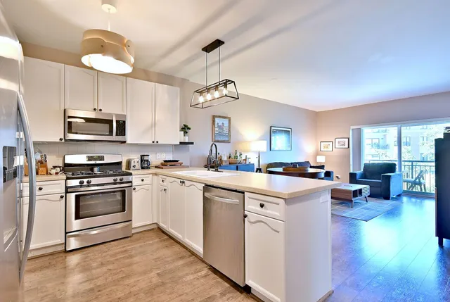 a kitchen with stainless steel appliances granite countertop a refrigerator a stove a sink and a microwave