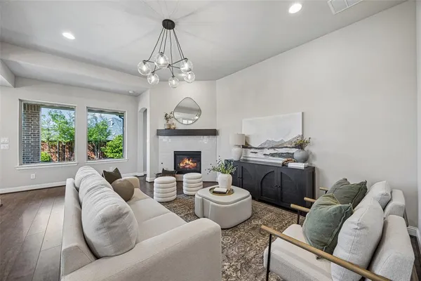 a living room with furniture a fireplace and a chandelier