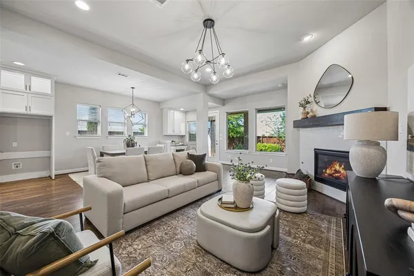 a living room with furniture a fireplace and a chandelier