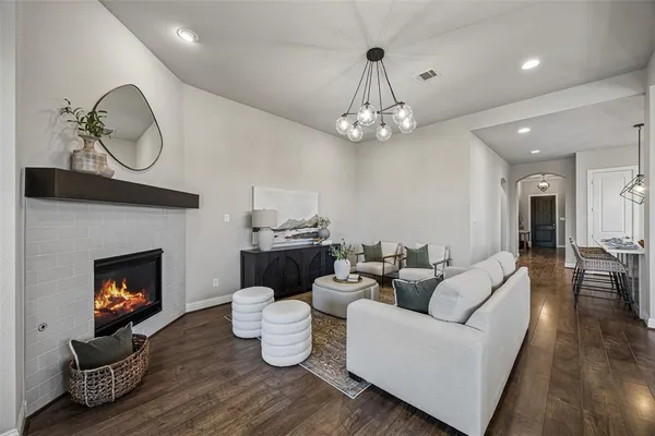 a living room with furniture a fireplace and a chandelier