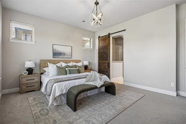 a spacious bedroom with a bed and a chandelier