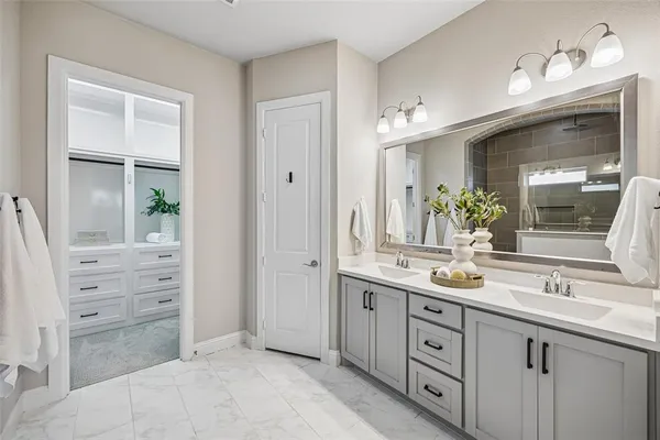 a spacious bathroom with a double vanity sink a large mirror and a