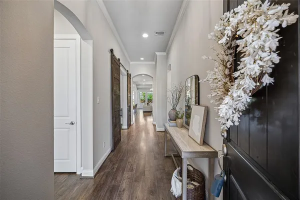 a view of a hallway with wooden floor and entryway
