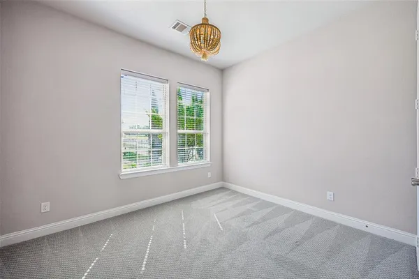 an empty room with windows and chandelier