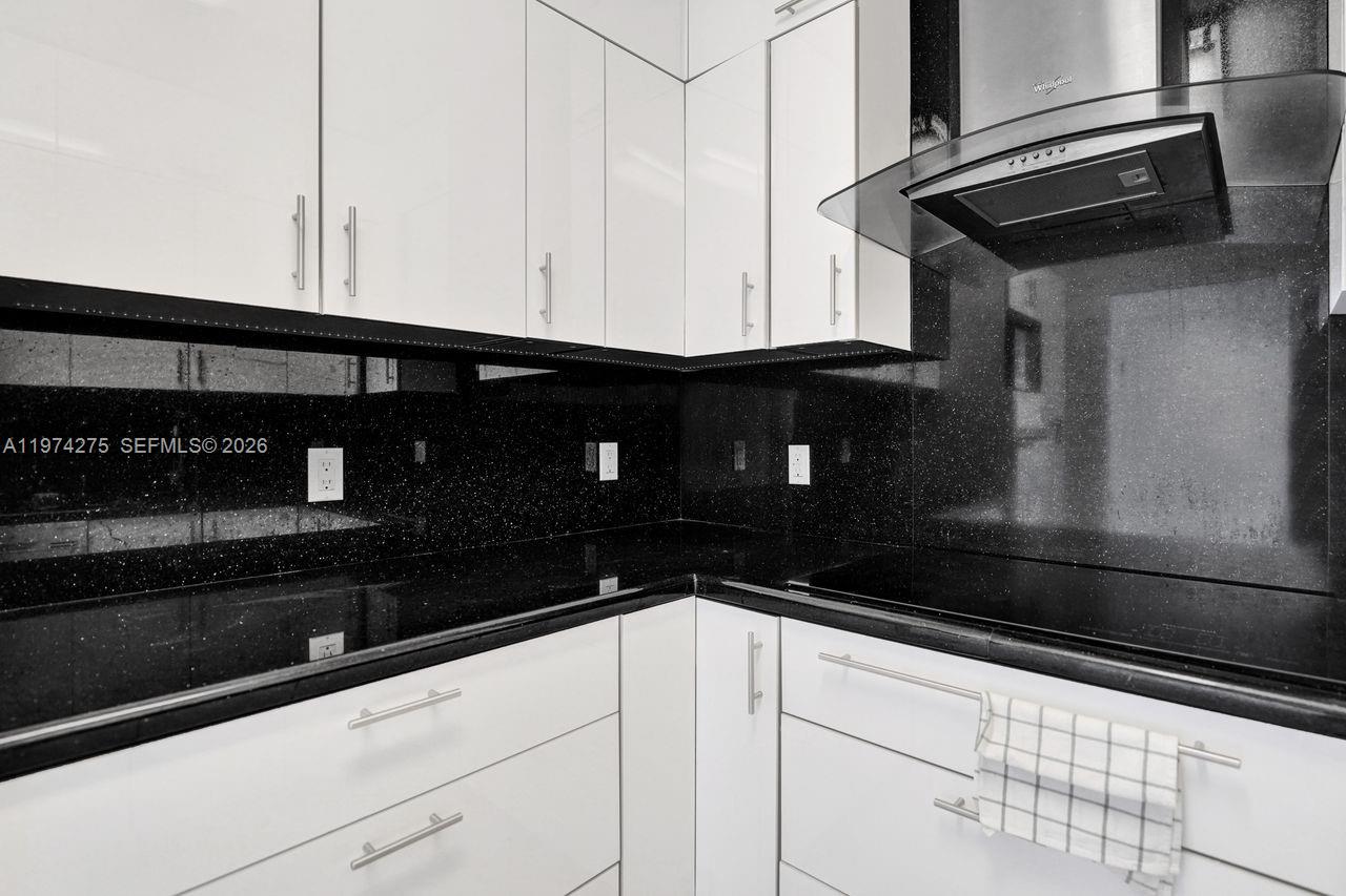 100 Lincoln Road, Unit PH12 Miami Beach, FL 33139 - Photo 16 of 59 a kitchen with granite countertop white cabinets and black appliances