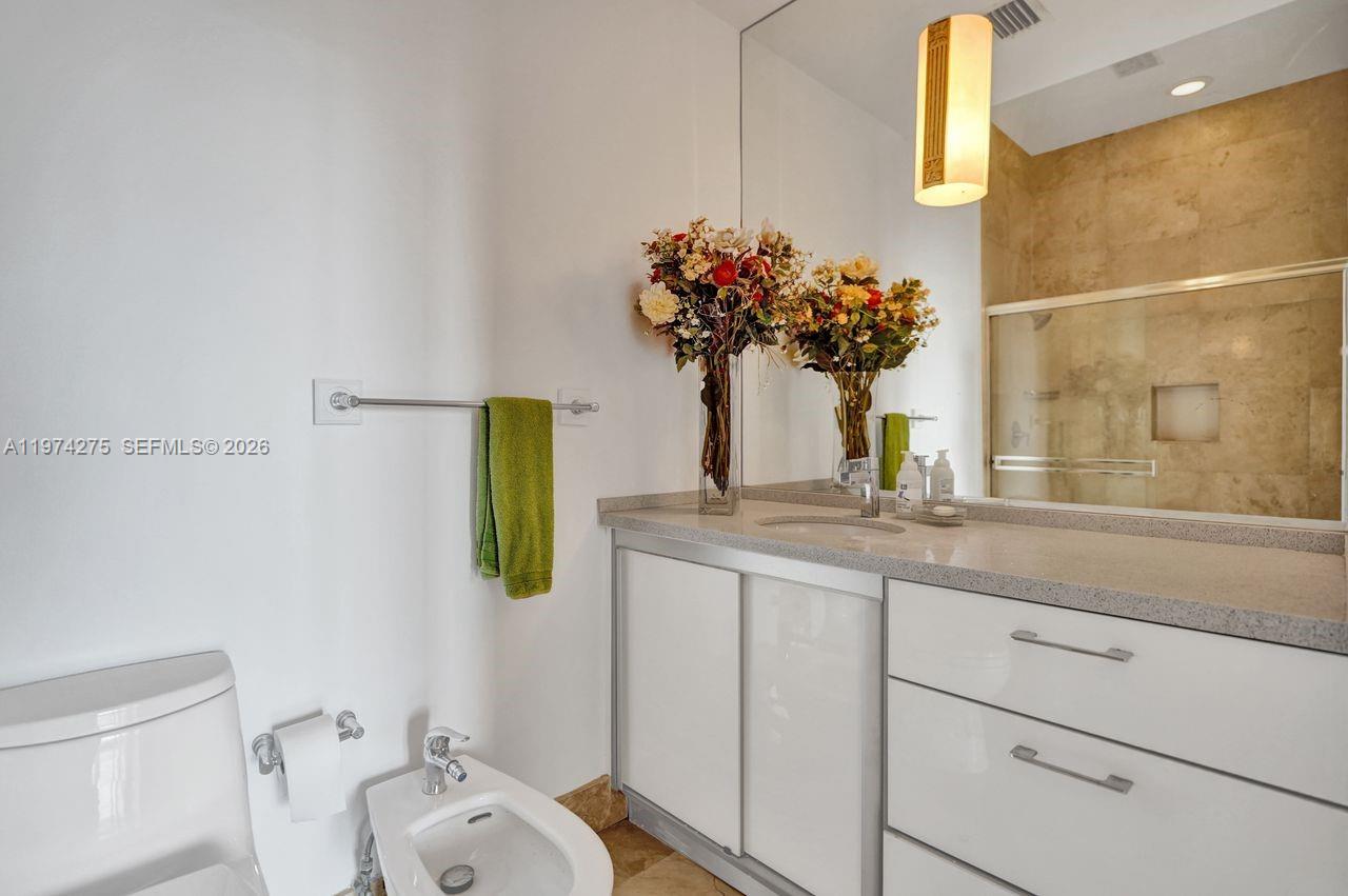 100 Lincoln Road, Unit PH12 Miami Beach, FL 33139 - Photo 34 of 59 a bathroom with a granite countertop sink a toilet and mirror