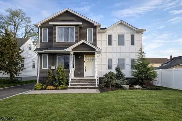a front view of a house with a yard and trees