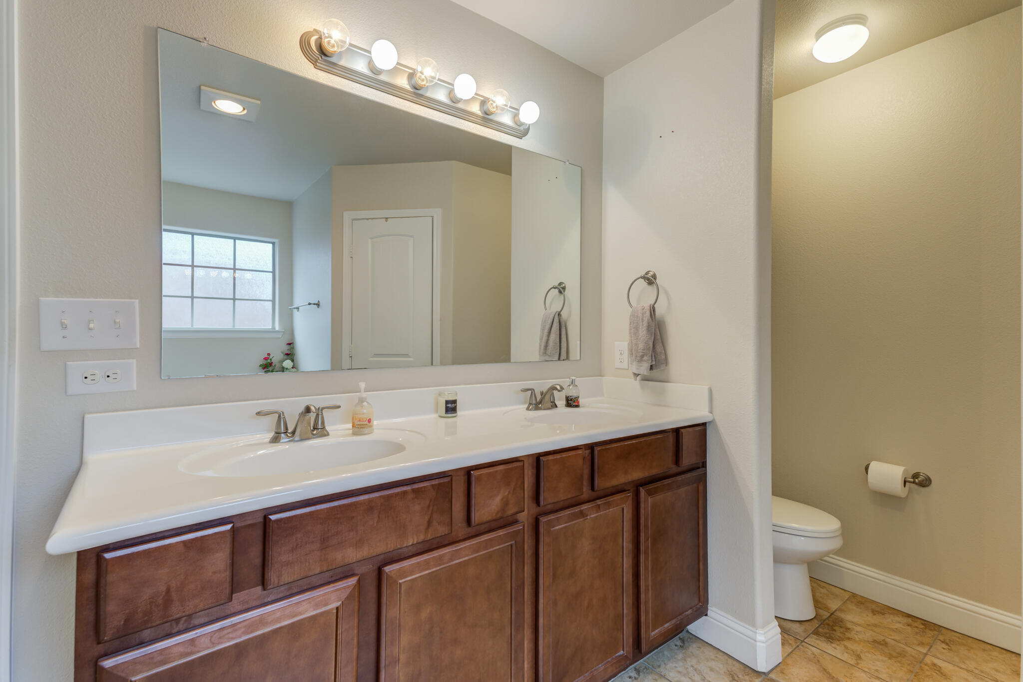 5747 110th Street Lubbock, TX 79424 - Photo 28 of 42 a bathroom with a double vanity sink mirror and toilet