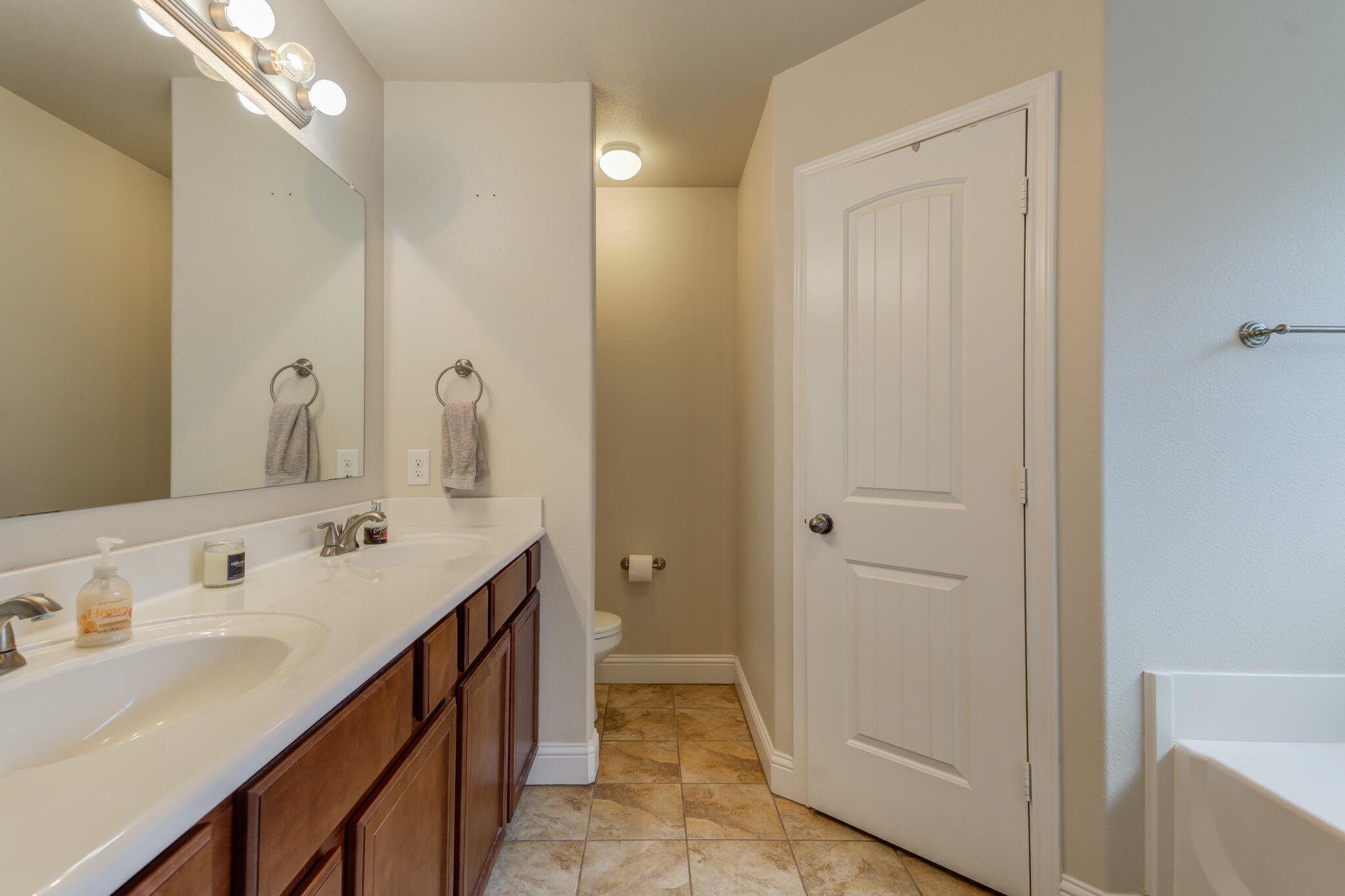 5747 110th Street Lubbock, TX 79424 - Photo 30 of 42 a spacious bathroom with double vanity and mirrors