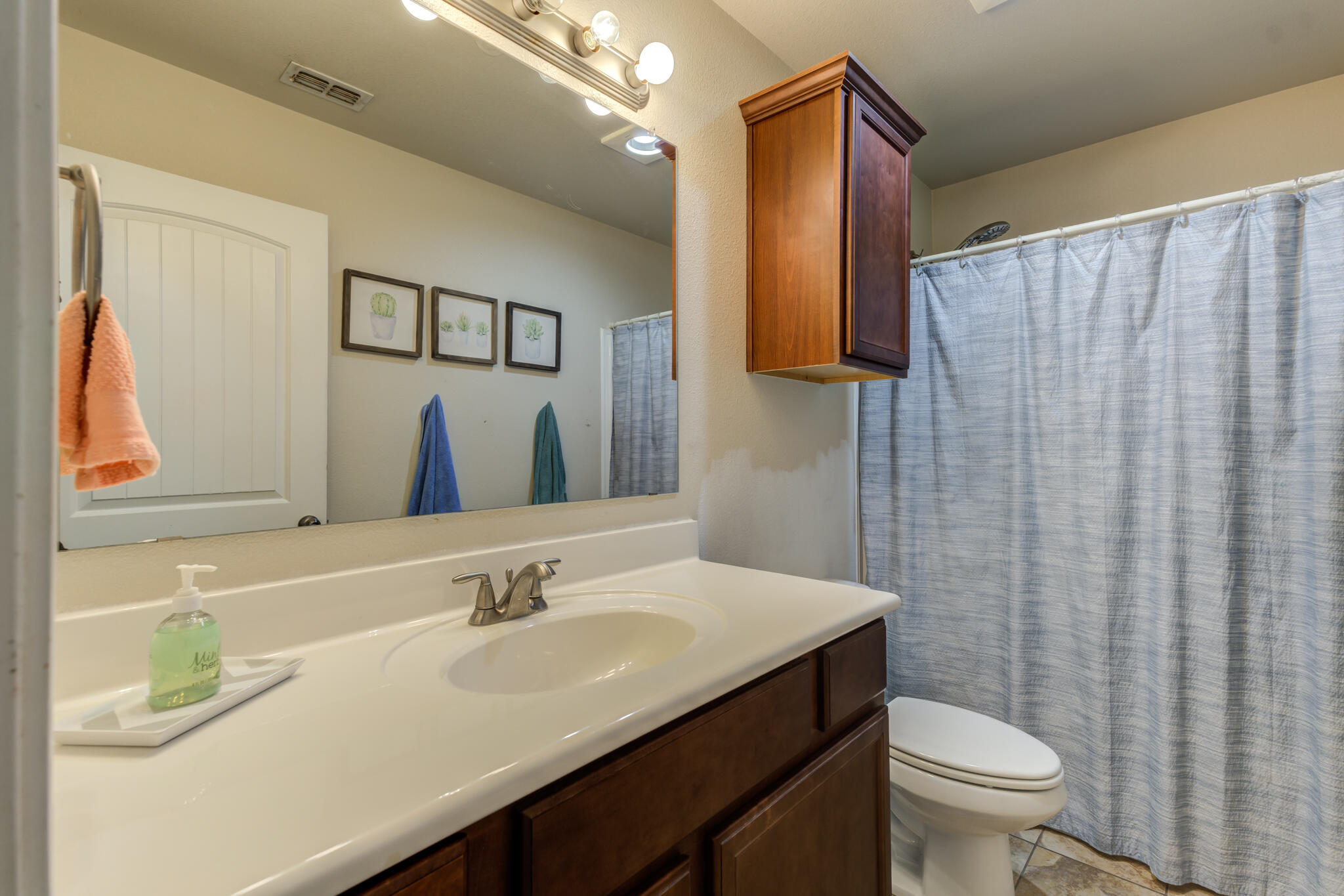 5747 110th Street Lubbock, TX 79424 - Photo 38 of 42 a bathroom with a granite countertop sink and a mirror