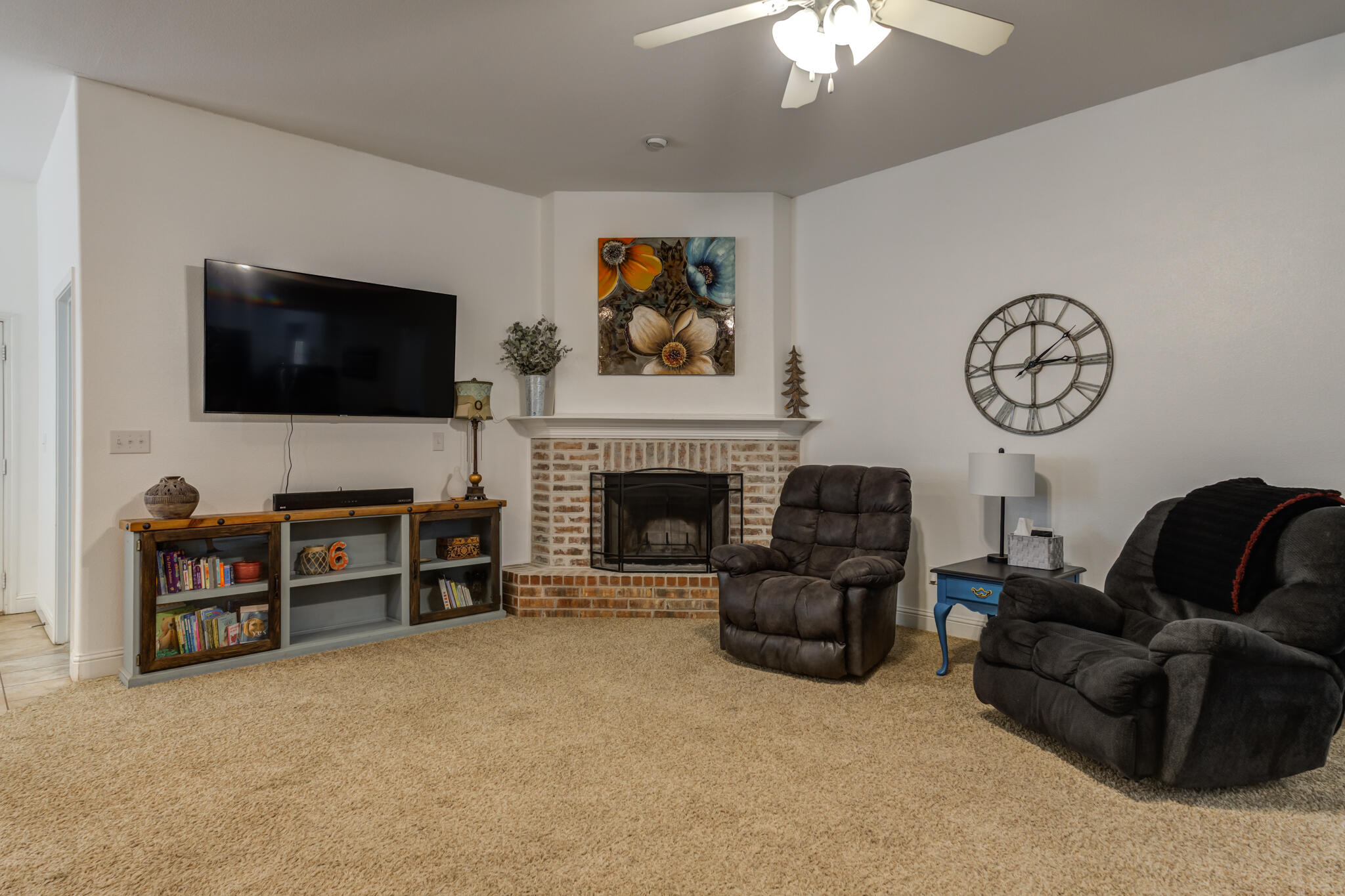 5747 110th Street Lubbock, TX 79424 - Photo 8 of 42 a living room with furniture a flat screen tv and a fireplace