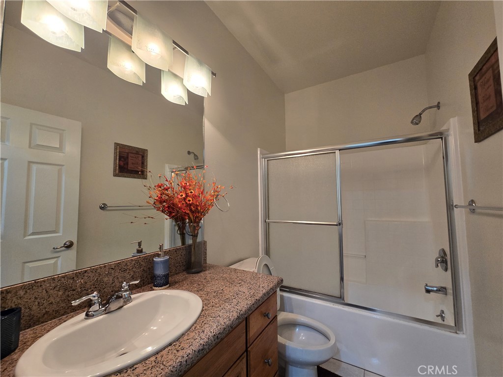 8026 Telegraph Road Downey, CA 90240 - Photo 18 of 26 a bathroom with a granite countertop sink toilet a large mirror and shower