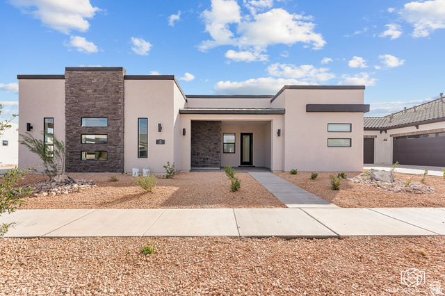 707 Spring Lily Drive St. George, UT 84790 - Photo 1 of 43 Contemporary stucco exterior with a flat roofline, stone accent wall, and multiple vertical and horizontal windows