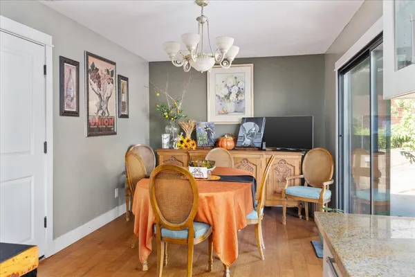 a dining room with furniture a chandelier and wooden floor