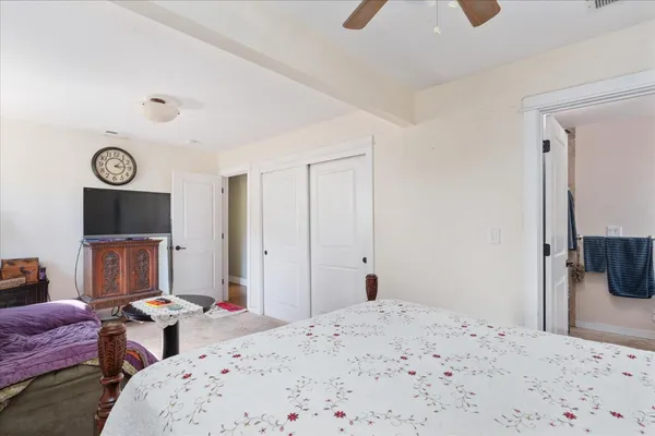 a bedroom with a bed and a dresser with wooden floor